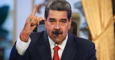 Nicolás Maduro vestido con un saco negro y corbata roja levantando un dedo.
